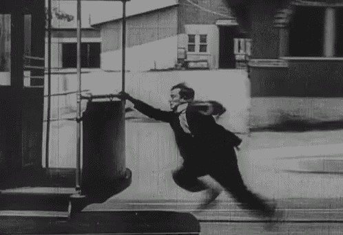 a black and white photo of a man flying through the air on a trolley .