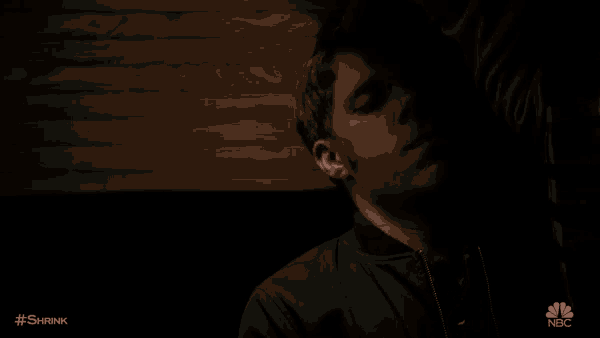 a man is sleeping on a chair in a dark room .