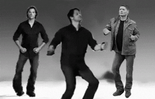 three men are standing next to each other and dancing in a black and white photo .