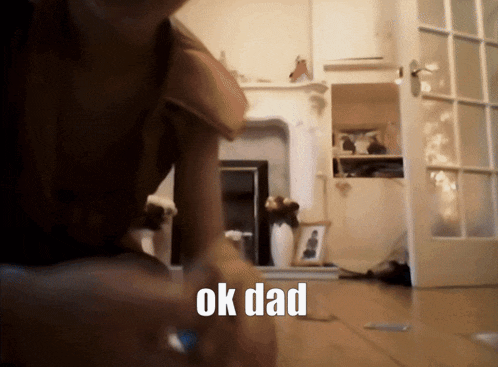 a blurred image of a person in a living room with the words ok dad written on the floor