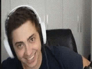 a man wearing headphones is sitting in a chair and smiling .