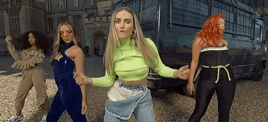a group of women are dancing in front of a van