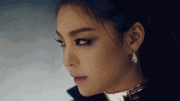 a close up of a woman 's face with a choker and earrings .