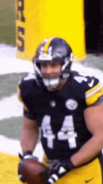 a football player wearing number 44 holds a football