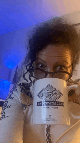 a woman wearing glasses is drinking from a mug that says aeropostale on it
