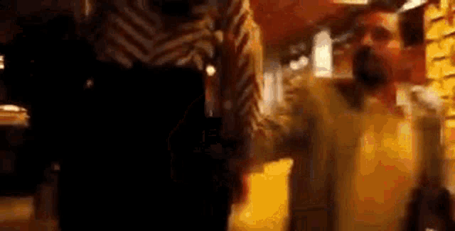 a man and a woman are standing next to each other in a dark room .