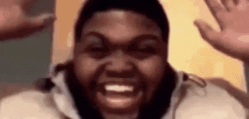a man with a beard is making a funny face and waving his hands in the air .