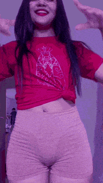 a woman wearing a red t-shirt and shorts is dancing .