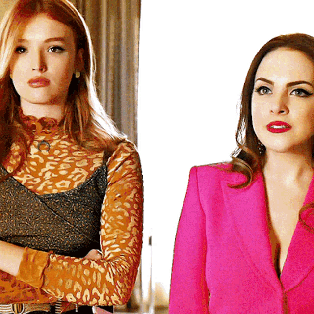 two women are standing next to each other one is wearing a leopard print top and the other is wearing a pink jacket