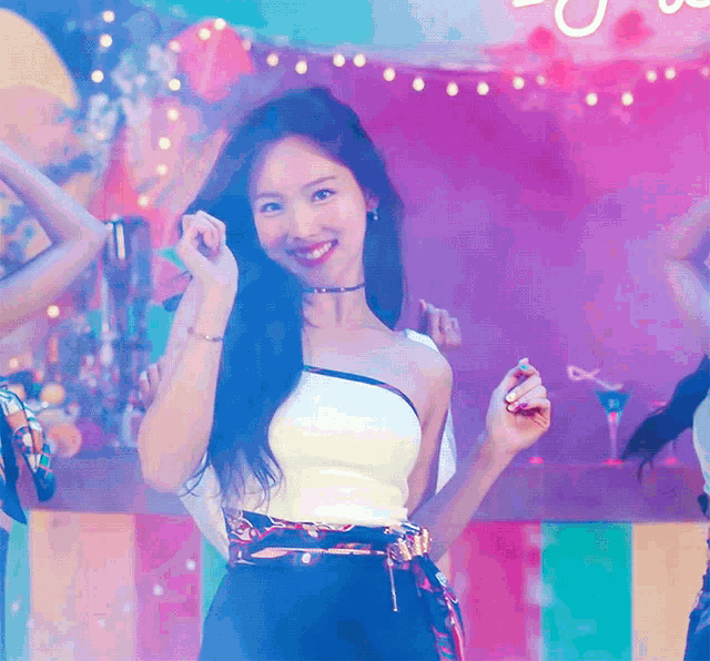 a woman in a white top and black pants is smiling and dancing
