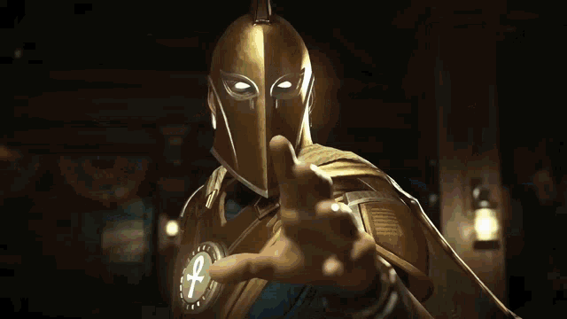 a man wearing a gold helmet with an ankh on it