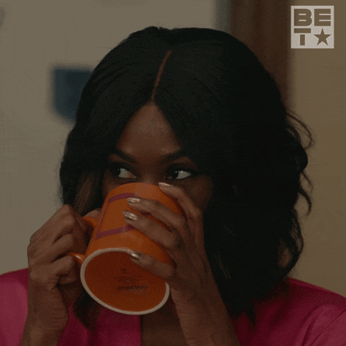 a woman is drinking from an orange mug with the word always on the side