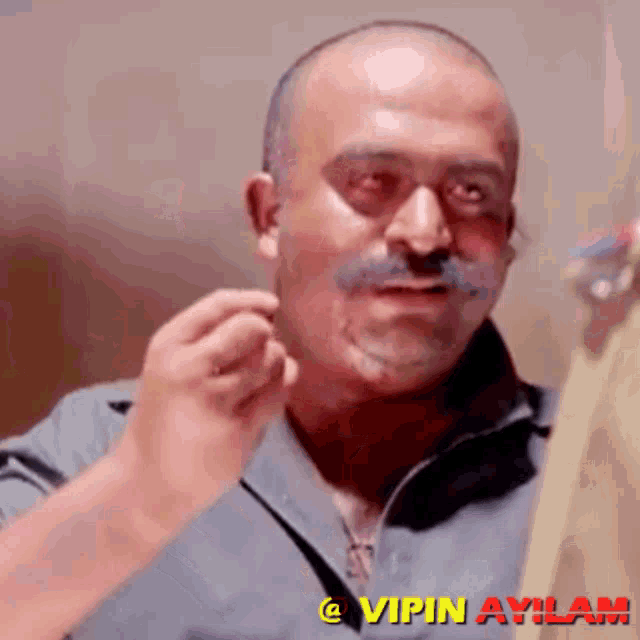 a man with a mustache has the name vipin aylam on the bottom of his face