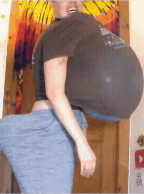 a woman with very large breasts is standing in front of a door and smiling .