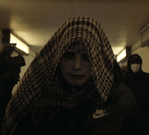 a man with a scarf around his head and a nike jacket