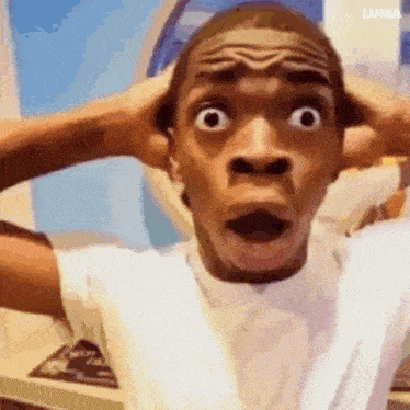 a man is making a funny face with his hands on his head and his mouth open .