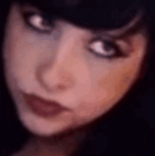 a blurry picture of a woman 's face with a serious look on her face