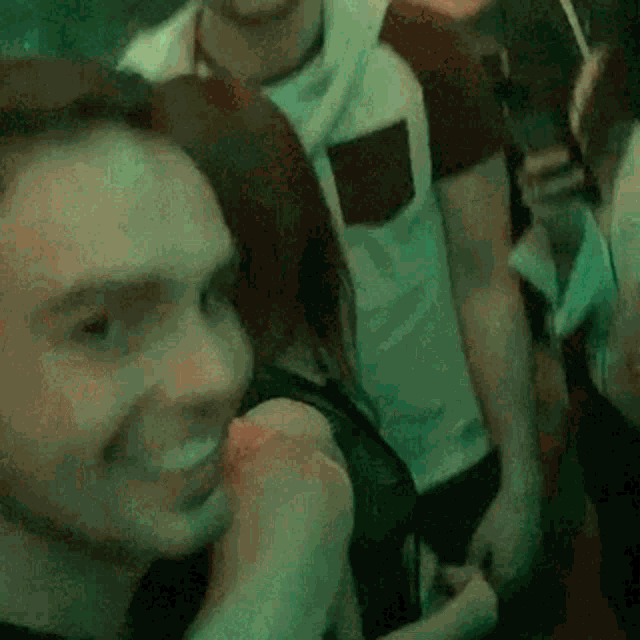 a man and a woman are standing next to each other in a crowd of people at a party .