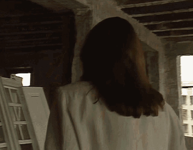 a woman in a white coat is standing in a room