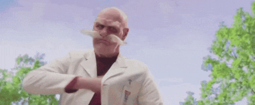 a man wearing a helmet , goggles and a mustache is eating a piece of meat .