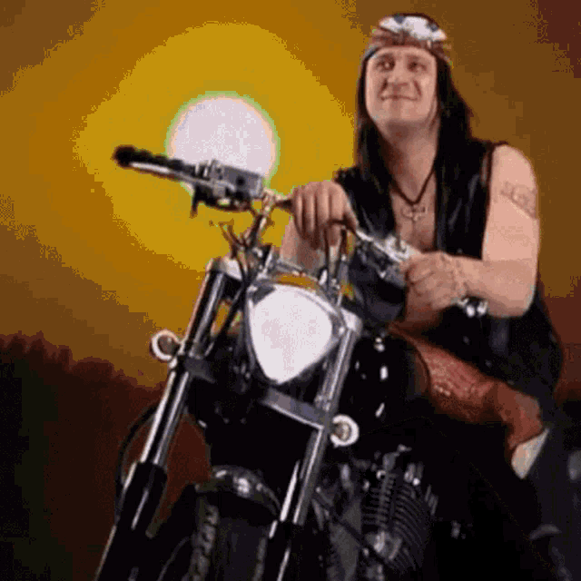 a man is sitting on a motorcycle with a cross on his neck