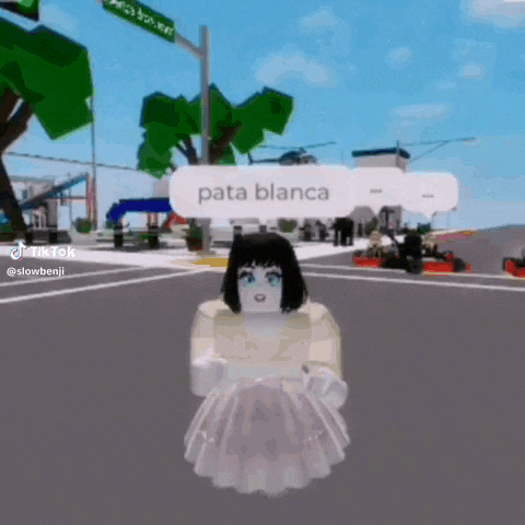 a girl in a white dress is standing in the middle of a street .