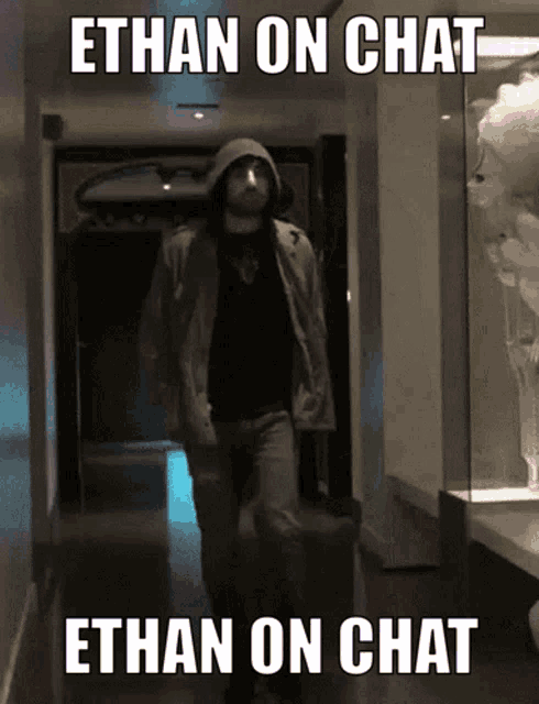a man in a hooded jacket walks down a hallway with the caption ethan on chat