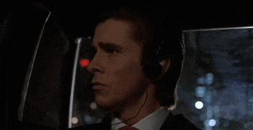 a man in a suit and tie wearing headphones looks out of a car window