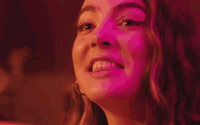 a close up of a woman 's mouth with a pink background