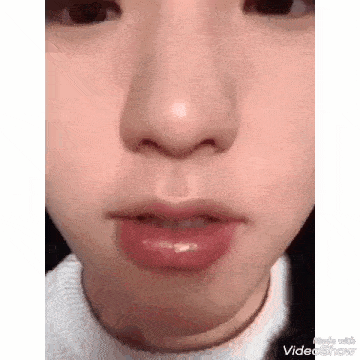 a close up of a woman 's face with her mouth open and her nose showing .