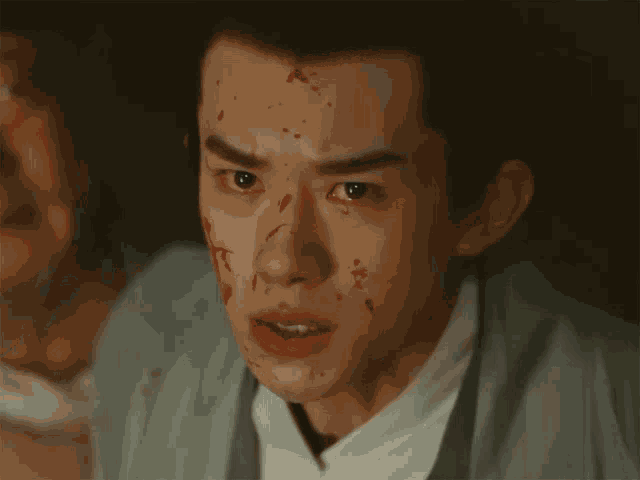 a man with blood on his face and a white shirt