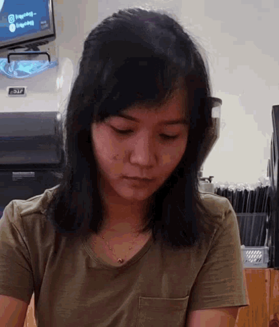 a woman in a green t-shirt is looking down