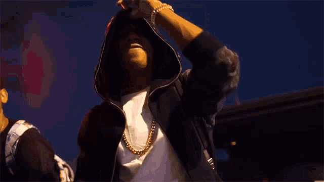 a man in a hooded jacket is holding a microphone in his hand
