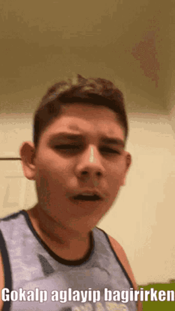 a boy in a purple tank top with the words gokalp aglayip bagirirken on the bottom