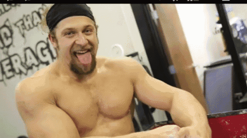 a shirtless man is sticking his tongue out in front of a wall that says " eragy " on it
