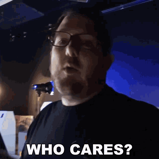 a man wearing glasses and a black shirt is asking who cares