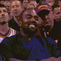 a man wearing a purple cavaliers hat smiles at the camera