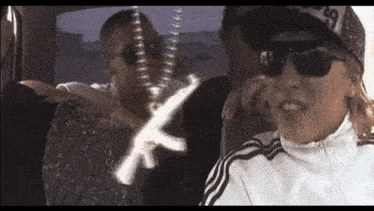 a group of people are sitting in a car and one of them is wearing sunglasses and a hat .