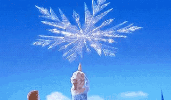 a person is holding a snowflake in their hand in front of a blue sky .