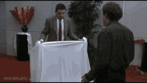 a movie clip from movieclips.com shows two men standing next to a table