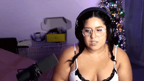 a woman wearing headphones and glasses is talking into a microphone
