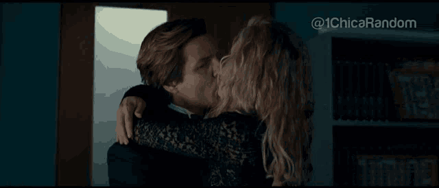 a man kissing a woman in front of a bookshelf with the hashtag @ 1chicas random