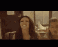 a woman with long hair is smiling in a blurry photo .