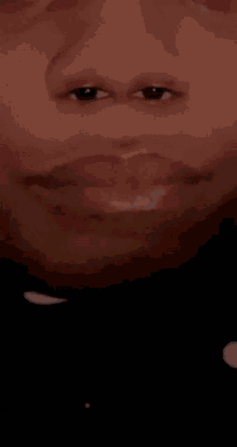 a close up of a man 's face with his mouth open and his eyes looking at the camera .