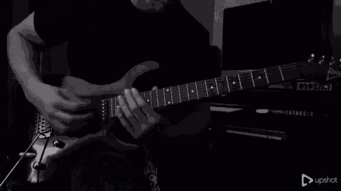 a man is playing a guitar in a black and white photo .