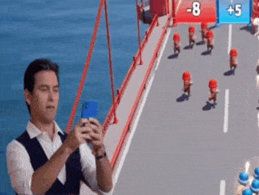 a man is taking a picture of a bridge with his cell phone .