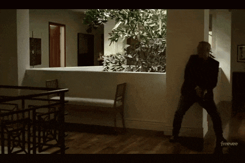 a man in a black suit stands in a hallway with a freevee logo in the corner
