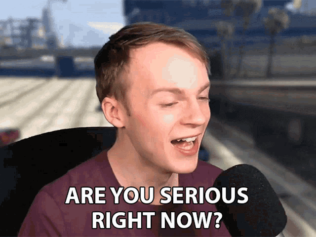a man is talking into a microphone with the words are you serious right now below him