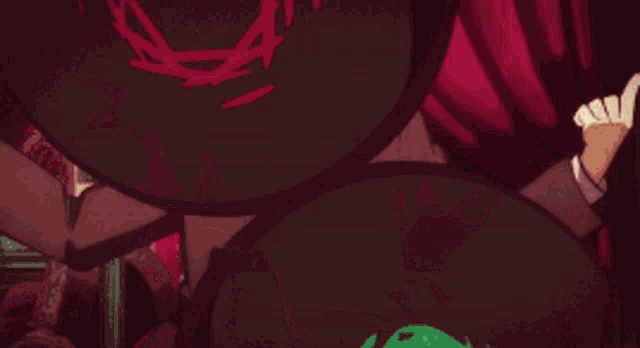a cartoon character is sitting in front of a red curtain with his hands up .