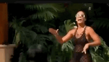 a woman in a black swimsuit is dancing in front of a man in a black shirt .